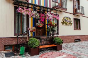 a bench in front of a building with flowers on it at Hotel Maria in Kropyvnytskyi