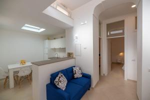 a living room with a blue couch and a kitchen at Marina Grande Holiday Apartment in Capri in Capri