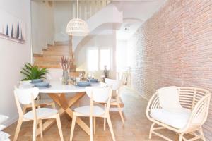 uma sala de jantar com uma parede de tijolos e uma mesa e cadeiras em Allegra Boutique House em Palamós