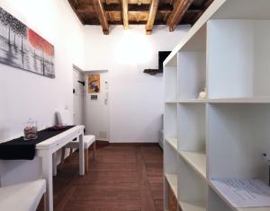 ローマにあるRomantica Navonaの白いテーブルと白い棚が備わる部屋