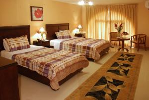 a hotel room with two beds and a table and chairs at Jardaneh Hotel in Aqaba