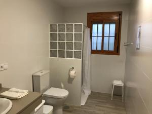a bathroom with a toilet and a sink and a window at El cortijo de la abuela in Benahadux