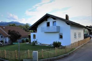 Biały dom z płotem przed nim w obiekcie Ferienwohnung Das Inge De Unterne w mieście Bernau am Chiemsee