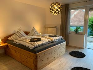 1 dormitorio con cama de madera y almohadas en Ferienwohnung Das Inge De Unterne en Bernau am Chiemsee