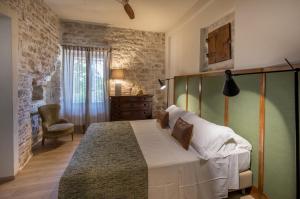 - une chambre avec un grand lit et une chaise dans l'établissement I Casali di Villa Benveduti, à Gubbio