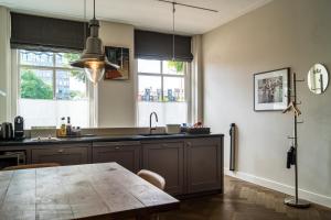 a kitchen with a wooden table and some windows at B&B Amsterdam Amstel Apartment in Amsterdam