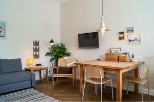 a living room with a dining room table and a blue couch at B&B Amsterdam Amstel Apartment in Amsterdam