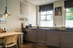 a kitchen with gray cabinets and a wooden table at B&B Amsterdam Amstel Apartment in Amsterdam