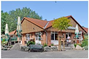 un bâtiment avec des chaises et des parasols en face de celui-ci dans l'établissement Gästehaus Lietzow & Störtebeker Camp, à Lietzow