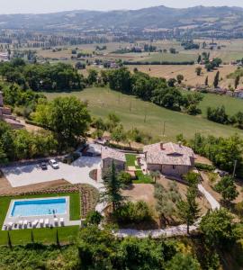 eine Luftansicht der Unterkunft mit einem Pool und einem Haus in der Unterkunft I Casali di Villa Benveduti in Gubbio