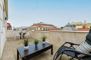 d'un balcon sur le toit avec une table et des chaises. dans l'établissement MalagaSuite Soho apartment, à Malaga