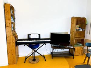 a room with a keyboard and a desk with a computer at Ferienwohnung Fuchsbau in Brombachtal