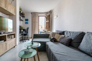 - un salon avec un canapé bleu et 2 tables dans l'établissement MalagaSuite Soho apartment, à Malaga