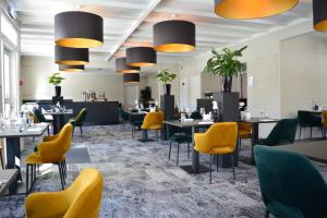 a dining room with tables and yellow chairs at Fletcher Hotel Restaurant De Gelderse Poort in Ooij