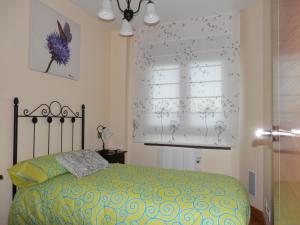 Un dormitorio con una cama y una ventana con motivos de nieve en Casa Rural El Dolmen, en Bernúy-Salinero