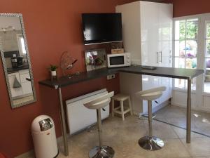 a kitchen with a table with a microwave and stools at Dépendance individuelle in Nans-les-Pins