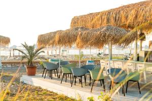 a row of chairs and a bar with a straw umbrella at Sunrise Blue Magic Resort - All Inclusive in Obzor