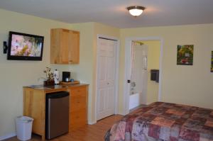 a bedroom with a bed and a dresser and a bathroom at Dogwood Bed & Breakfast in Summerland