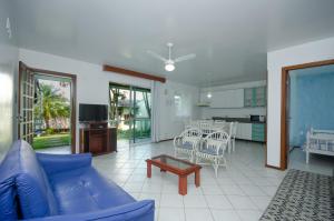 a living room with a blue couch and a table at Pousada Morada da Praia in Bombinhas