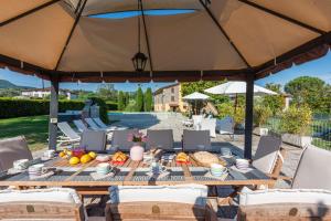 a wooden table with food on it under a large umbrella at Villa Leone in San Gennaro