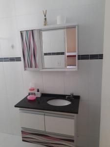 ein Badezimmer mit Waschbecken und Spiegel in der Unterkunft Casa Ampla e Confortável a 10 minutos Praia Ubatumirim Cambuca in Ubatuba