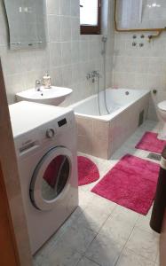 a bathroom with a washing machine and a bath tub at Holiday Home Iman in Sarajevo +26 photos