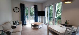 ein Wohnzimmer mit einem Sofa, einem Tisch und einer Uhr in der Unterkunft Wohnen am Südstrand - Ferienwohnung 1 7 in Wyk auf Föhr