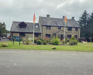 a house with two flags in front of it at Spencers Retreat at Percy Wood Country Park in Newton on the Moor