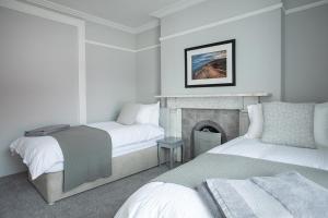 a bedroom with two beds and a fireplace at Rooms@Mourne in Dundrum