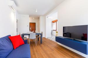 salon z niebieską kanapą i telewizorem w obiekcie Venice Lido Wonderful Apartment with Terrace w Lido di Venezia