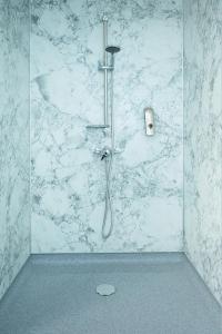 a shower in a bathroom with a marble wall at Rooms@Mourne in Dundrum