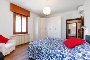sypialnia z niebieskim i czerwonym łóżkiem oraz kanapą w obiekcie Venice Lido Wonderful Apartment with Terrace w Lido di Venezia