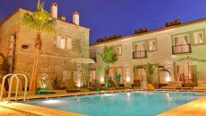 a hotel with a swimming pool in front of a building at Jardin d'Azur Alaçatı in Alacati