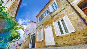 a building with white doors and windows on a street at Jardin d'Azur Alaçatı in Alacati