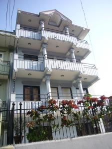 um edifício branco com flores em frente em Le Rhododendron Chambres D'hotes em Kathmandu