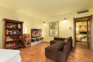 a living room with a couch and a tv at Toscana da Sogno a Villa Allegria in Siena
