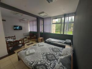 a room with two beds and a table in it at S Apartmani Priboj in Čitluk