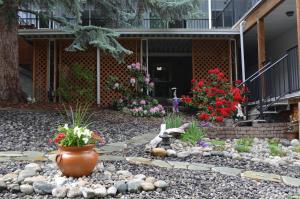 a garden in front of a house with flowers at Dogwood Bed & Breakfast in Summerland
