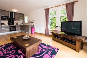 a large living room with a tv and a table at The Claymore Guest House in Pitlochry