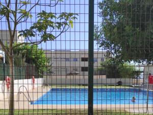 a swimming pool in front of a building at Habitaciones en Casa compartida Retamar in Almería