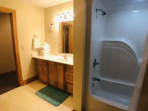 a bathroom with a tub and a sink and a shower at Briarstone Lodge Condo 13B in Pigeon Forge +23 photos