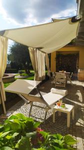 patio z krzesłami, stołem i parasolem w obiekcie La Morra Suite w mieście La Morra