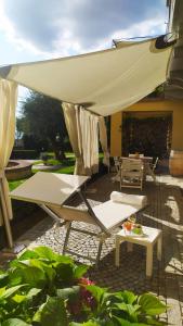 eine Terrasse mit Stühlen, einem Tisch und einem Sonnenschirm in der Unterkunft La Morra Suite in La Morra