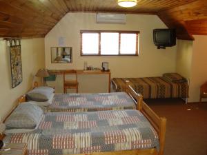 1 Schlafzimmer mit 2 Betten, einem TV und einem Tisch in der Unterkunft Pentzhaven Guesthouse in Table View