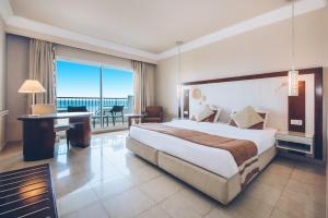 a hotel room with a large bed and a balcony at Iberostar Selection Royal El Mansour in Mahdia