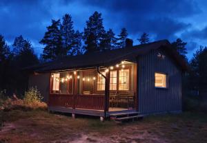 una casa pequeña con luces encendidas por la noche en Björnbyn Stugby, en Råda