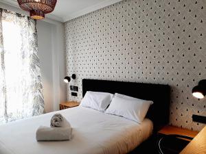 un dormitorio con una cama con un animal de peluche en Hotel Matilde by gaiarooms, en Salamanca