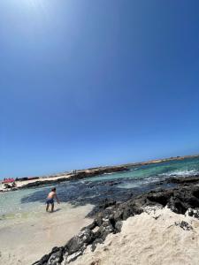 a man playing in the water on the beach at COTILLO SEA in Cotillo