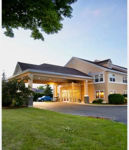 un gran edificio con un coche aparcado en la entrada en Coos Motor Inn, en Lancaster