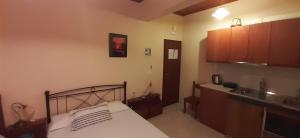 a bedroom with a bed and a kitchen in it at Toulatos Pantelis in Pouláta +59 photos